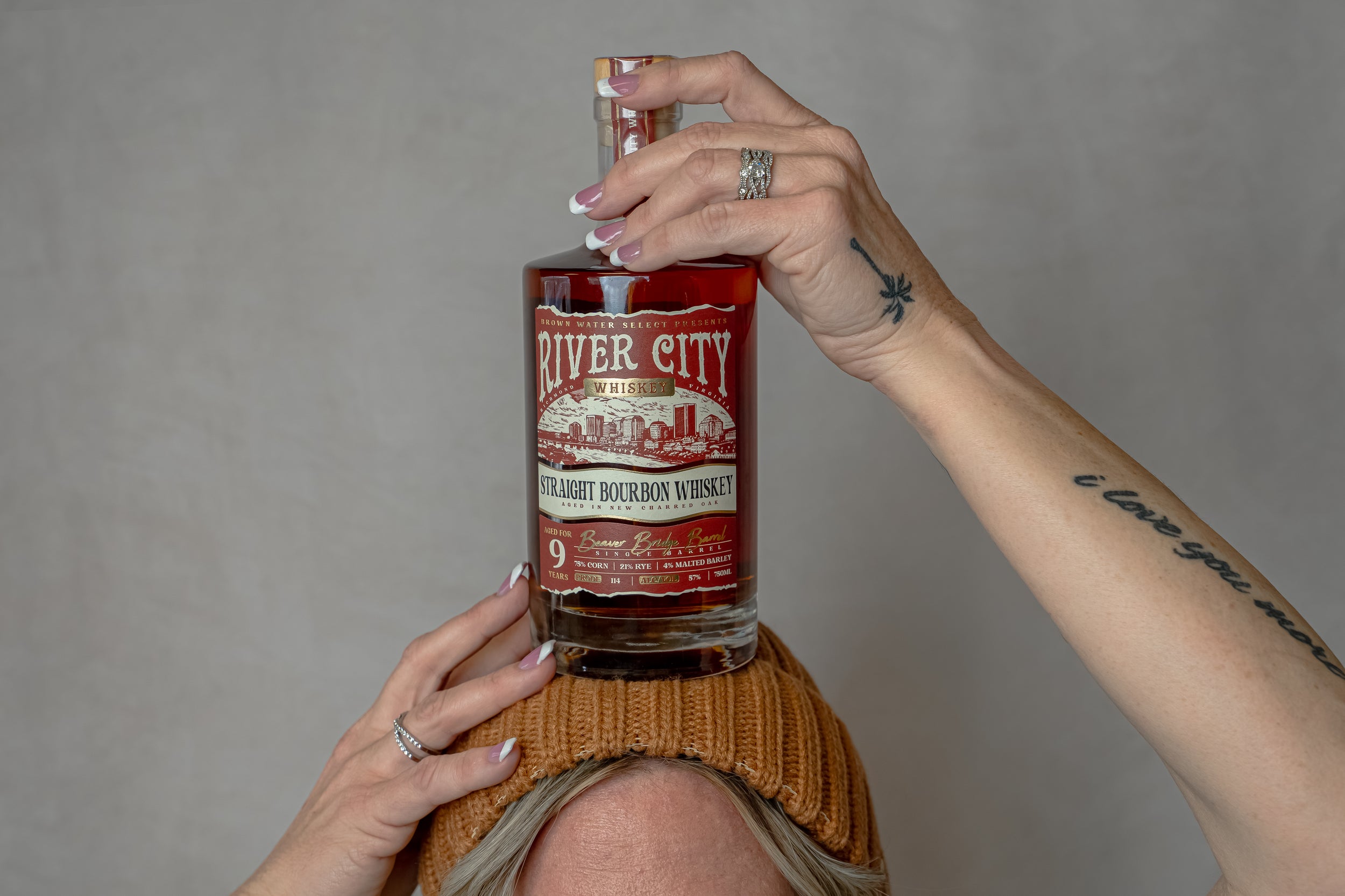 A bottle of River City Whiskey balancing on a married womans head